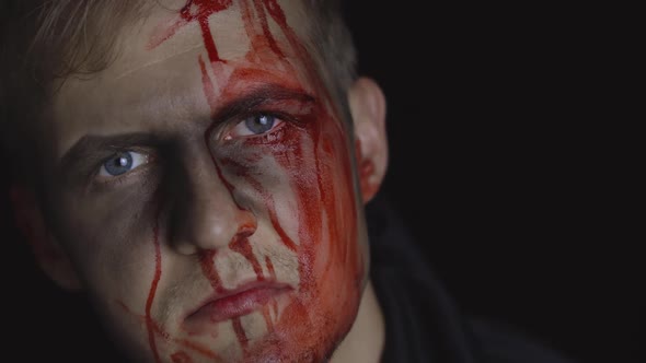 Halloween Man Portrait. Guy with Dripping Blood on His Face. Scary Makeup