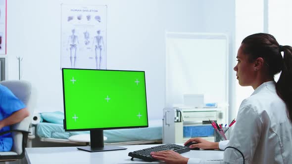 Doctor Using Computer with Green Screen Display