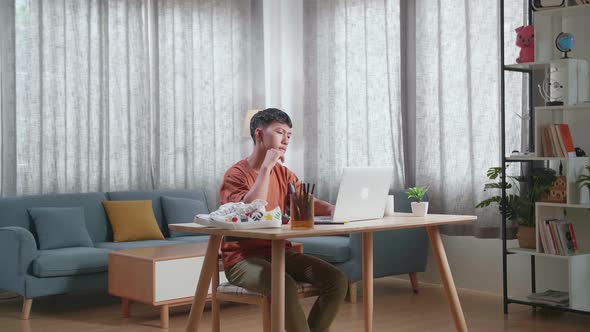 Asian Boy Footwear Designer Thinking While Working On A Laptop At Home