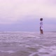 Girl Walks on the Beach on the Background of the Sea - VideoHive Item for Sale