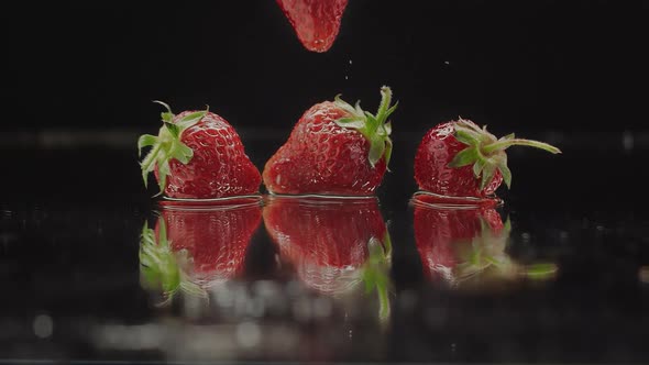 Fresh Strawberries Splashing on Slow Motion with Reflections for Natural Juicy