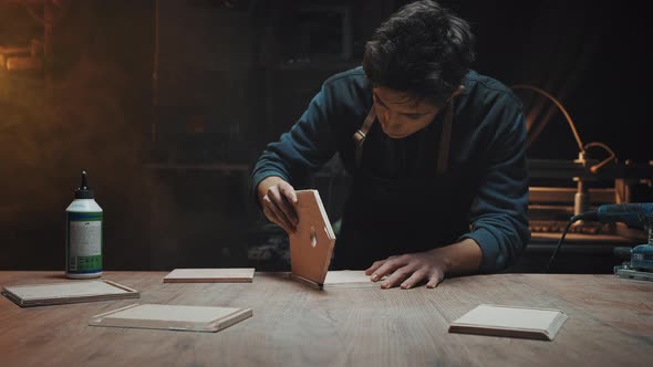 Attractive Brunette Carpenter is Gluing Together Wooden Blanks for a Birdhouse