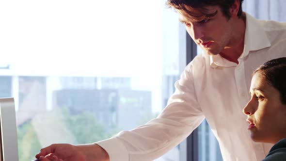 Businesswoman working with colleague at desk