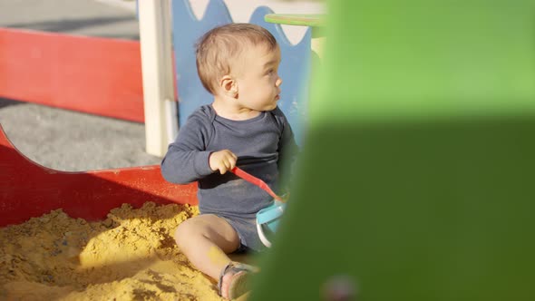 Toddler Boy Playing in Sand Box