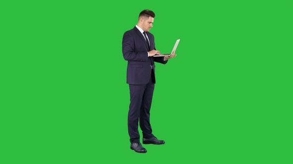 Businessman standing and using laptop on a Green Screen