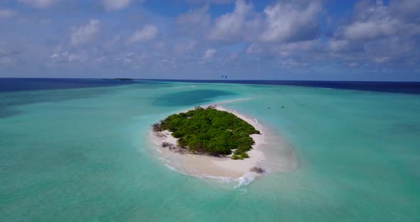 Natural aerial tourism shot of a paradise sunny white sand beach and turquoise sea background in 4K