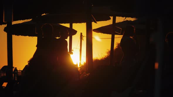 People at the beach against golden sunset