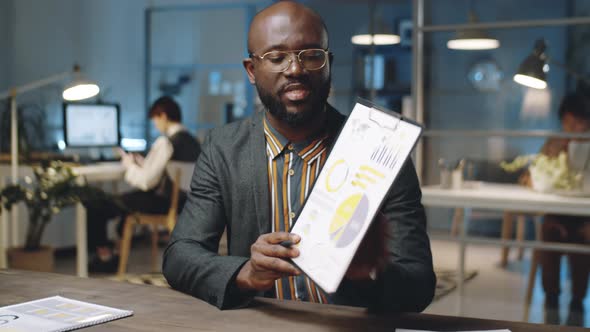 African American Businessman Giving Presentation on Camera in Office