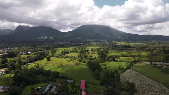 Slow aerial pull-in cameraement towards gigantic Mountain range in La Fortuna. Most active volcano o