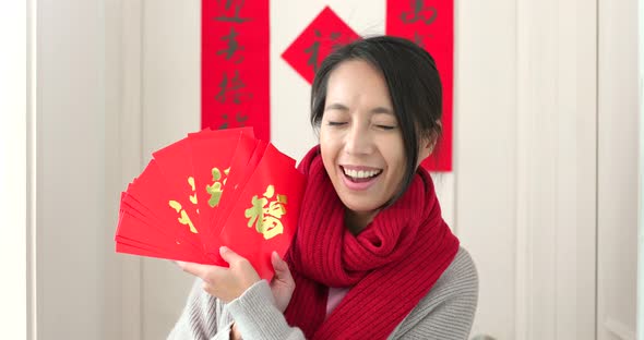 Chinese Woman Holding Red Packet and Feeling Happy, Word on Red Packet Means Luck