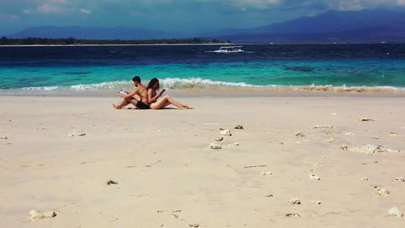 Family of two relax on marine coast beach trip by blue sea and white sand background of Gili Meno in