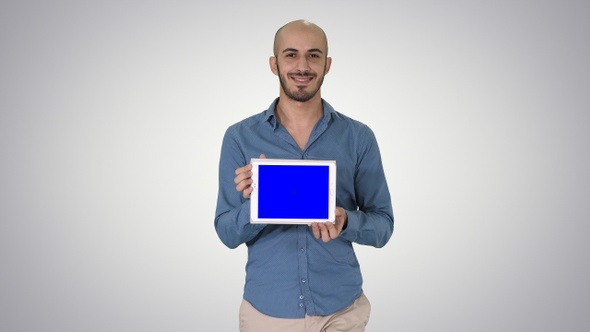 Arab man walking and showing tablet presenting something