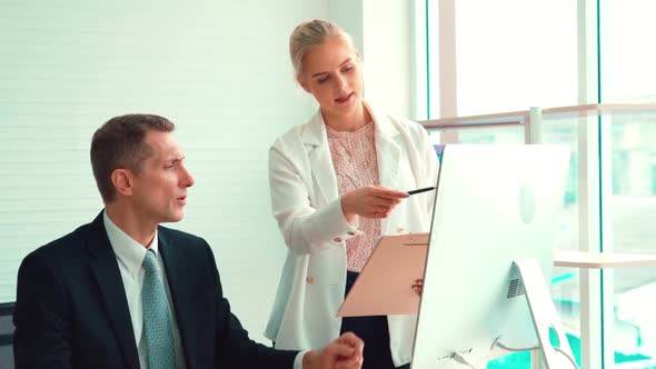 Two Business People Talk Project Strategy at Office