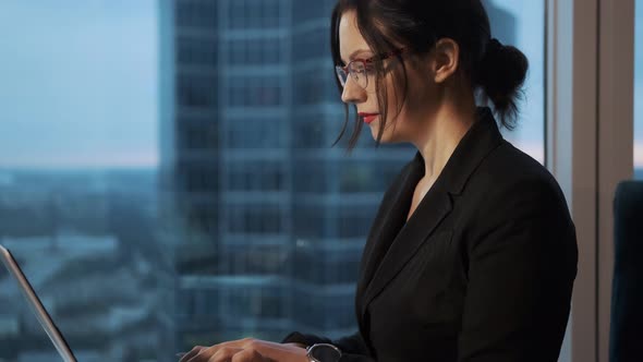 Young Woman Working in the Office Sitting By the Large Window. Portrait of a Business Woman Working