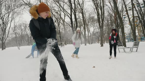 Children Teenagers Play Snowballs in the Park in Winter