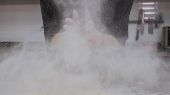 Chef Clapping His Hands with Flour Flour Flying in Different Directions