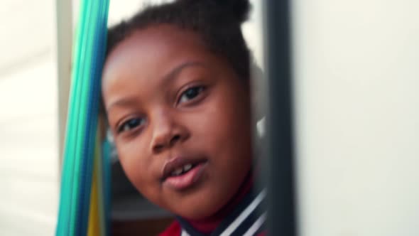 Happy little African girl talking from the trailer curtain