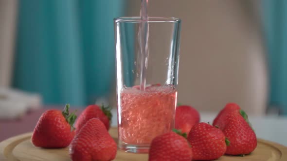 Fresh Delicious Strawberry Juice Pours Into a Glass