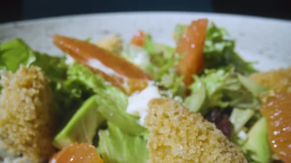 Salad with Grapefruit Green Lettuce Avocado Tuna and Cheese on Gray Plate Close Up