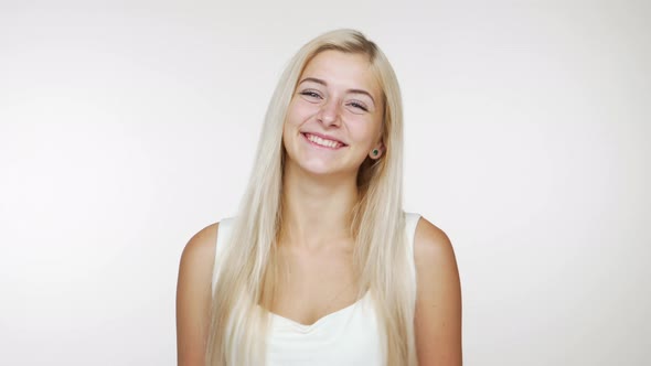 Beautiful Blond Lady Smiling Winking Flirting Giving Air Kiss on Camera Over White Background