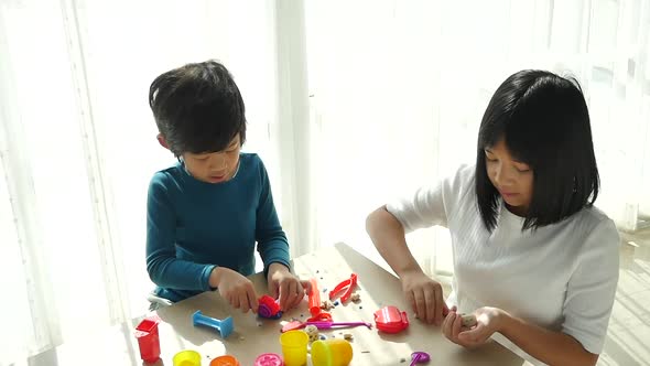 Asian Children Have A Fun Together With Colorful Modeling Clay At Home