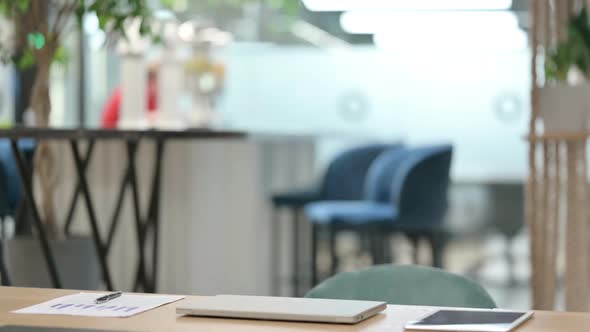 Young African Man Coming Back Opening Laptop in Modern Office