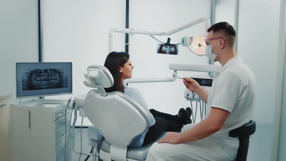 The Dentist Examines the Patient's Teeth in a Modern Dental Clinic