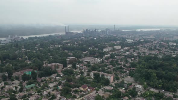 Aerial View of the City Near a Large Industrial Plant with Pipes and Smoke