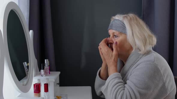 Old Senior Elderly Woman Grandmother Applying Anti-wrinkle Eye Patch, Putting Makeup on at Home