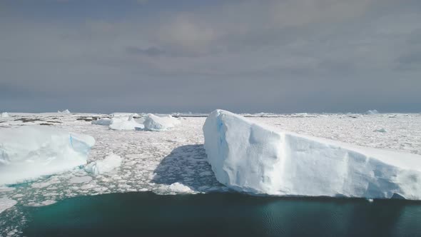 Sunlit Icebergs in Antarctica Ocean. Aerial Shot