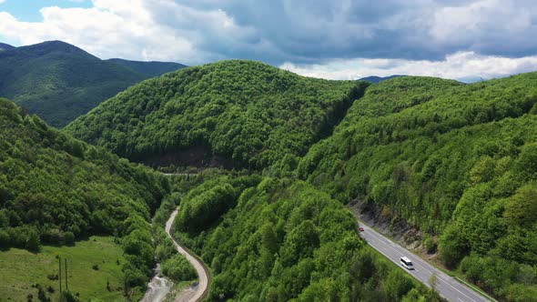 Traffic on the Mountain Car Road Along the River at the Sunny Day Aerial View