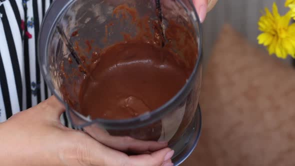 A Woman Demonstrates A Banana Chocolate Smoothie. In A Blender Bowl. Shot Close Up.