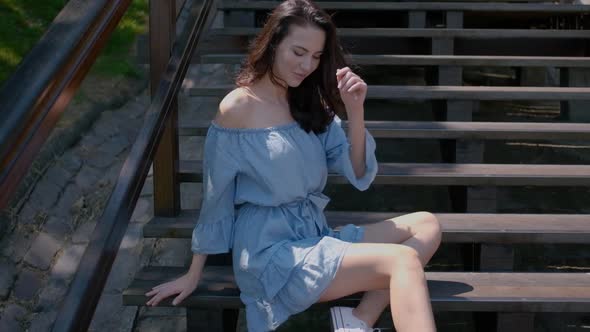 Adorable Brunette Woman Sitting on Stairs in Outdoor