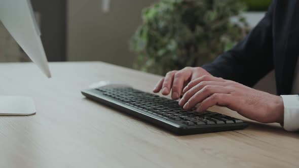 Close Up of a Businessman's Hand Typing on the Computer Keyboard