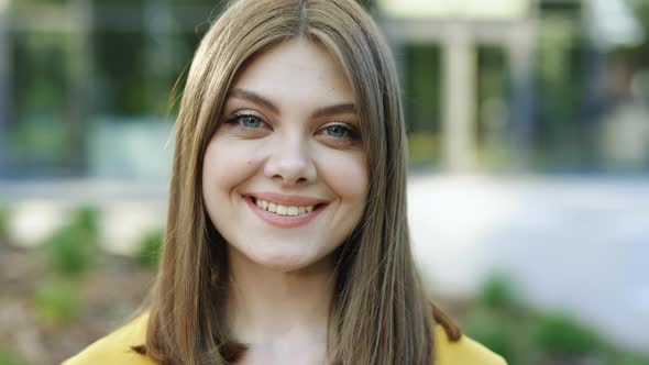 Face Portrait of Woman in Business Formal Suit Smiling and Posing Near Modern Buildings Outside