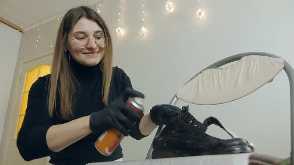 A Beautiful Girl Takes Care of Shoes at Home