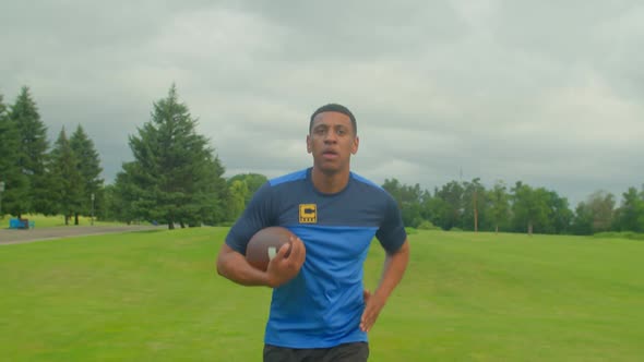 Portrait of Fit African American Football Player with Ball Running on Field