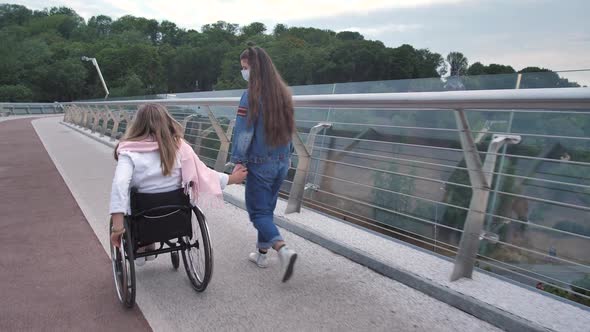 Masked Disabled Mom and Her Girl Walking on Bridge