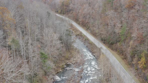 Drone shot of river and road looking downstream rising altitude in late fall in western North Caroli