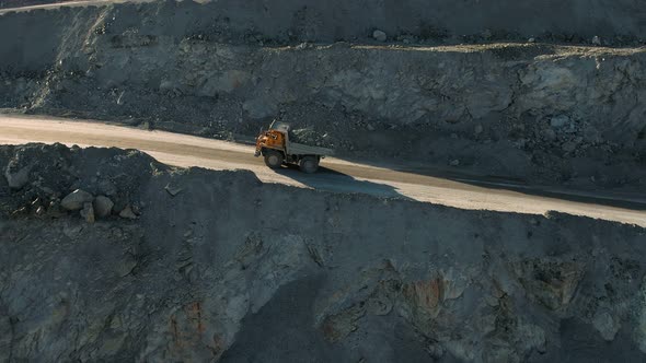 Open pit iron ore mining, a big yellow mining truck at work, working in a quarry. Dump Truck