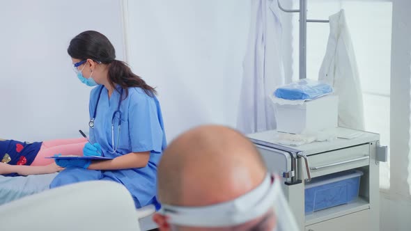 Nurse Talking with Child Laying in Bed