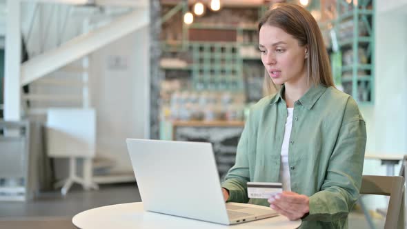 Woman with Successful Online Payment on Laptop in Cafe 