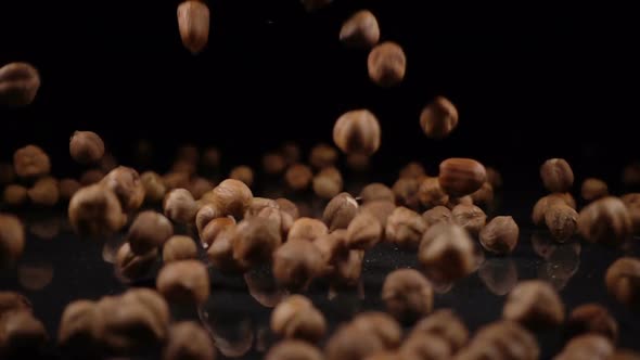 Hazelnuts Falling on a Hard Black Surface