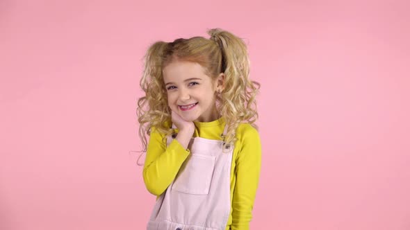 Cute Naughty Girl Making Faces on Pink Background. Slow Motion