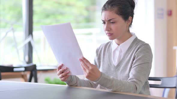 Beautiful Indian Woman Reading Document Having Loss at Work