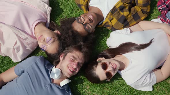 Top View of Diverse Students Lying on Grass and Smiling