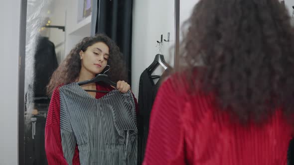 Female Shopper Is Comparing Two Dress Different Colors in Changing Room