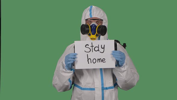 Portrait of a Man in a Protective Suit, Goggles, Gloves and a Respirator Looking at the Camera