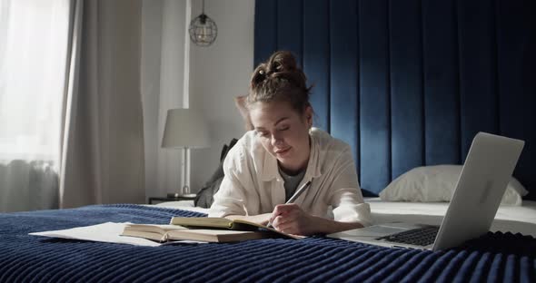 Female Student Using Laptop on Bed