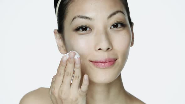 Young woman cleansing her face